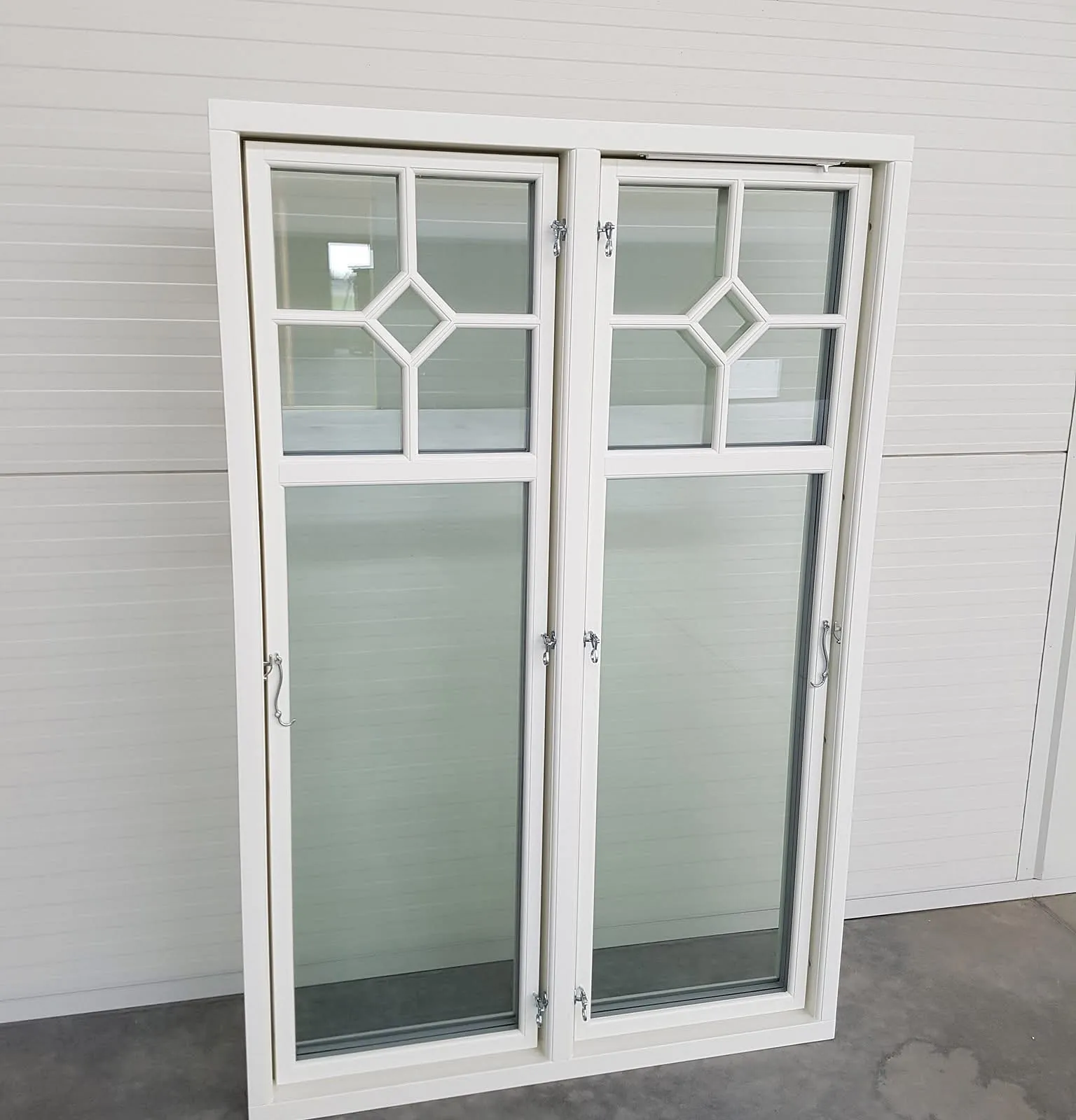 Hvitt vindu med fire glassfelt og diamantform.